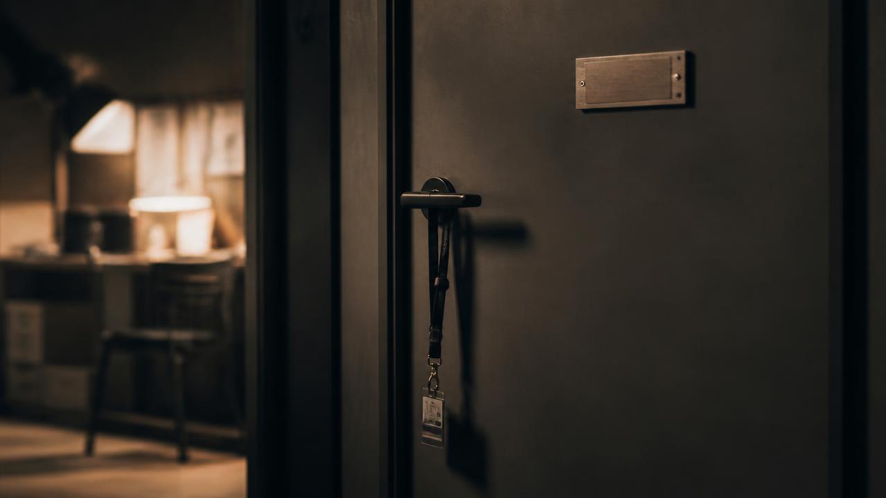 A badge on a lanyard hanging from a locked production office door